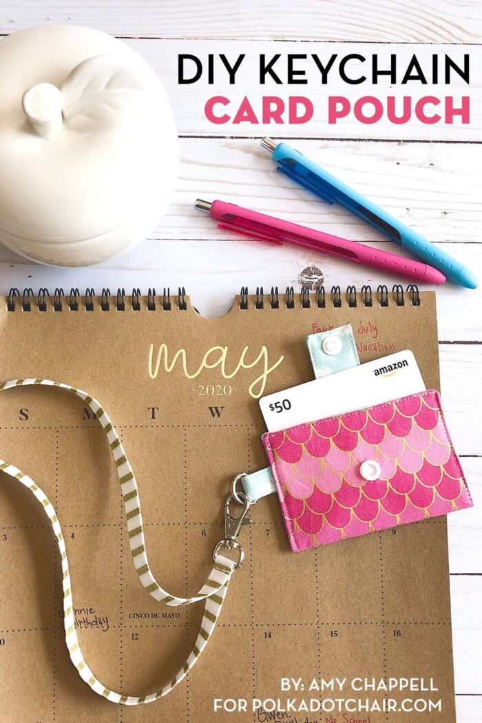 pink keychain card pouch on brown calendar on white tabletop