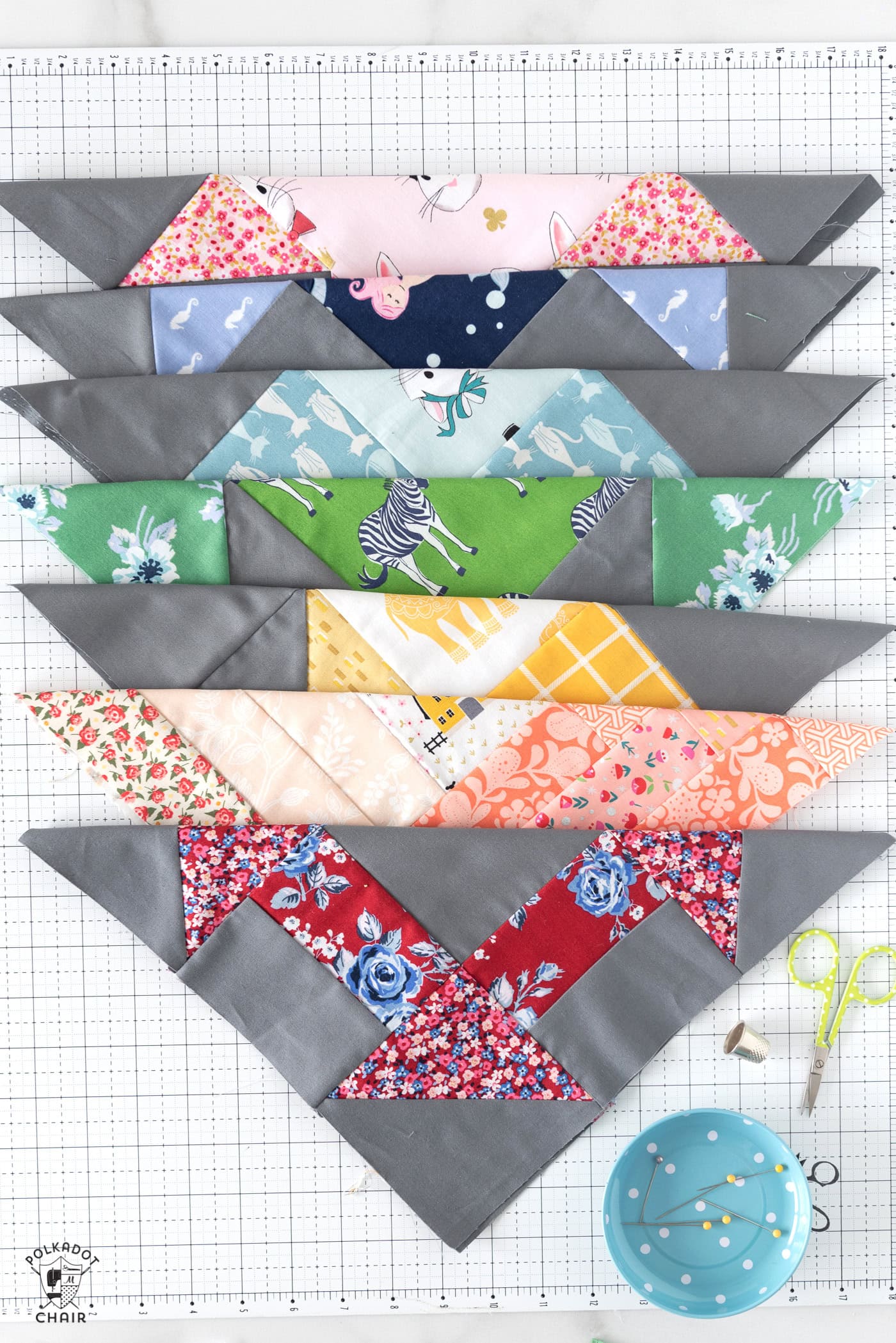 many colorful quilt blocks on cutting mat folded in half