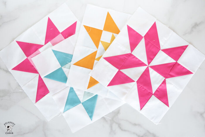 sawtooth star quilt blocks in blues, pinks and yellows on white tabletop
