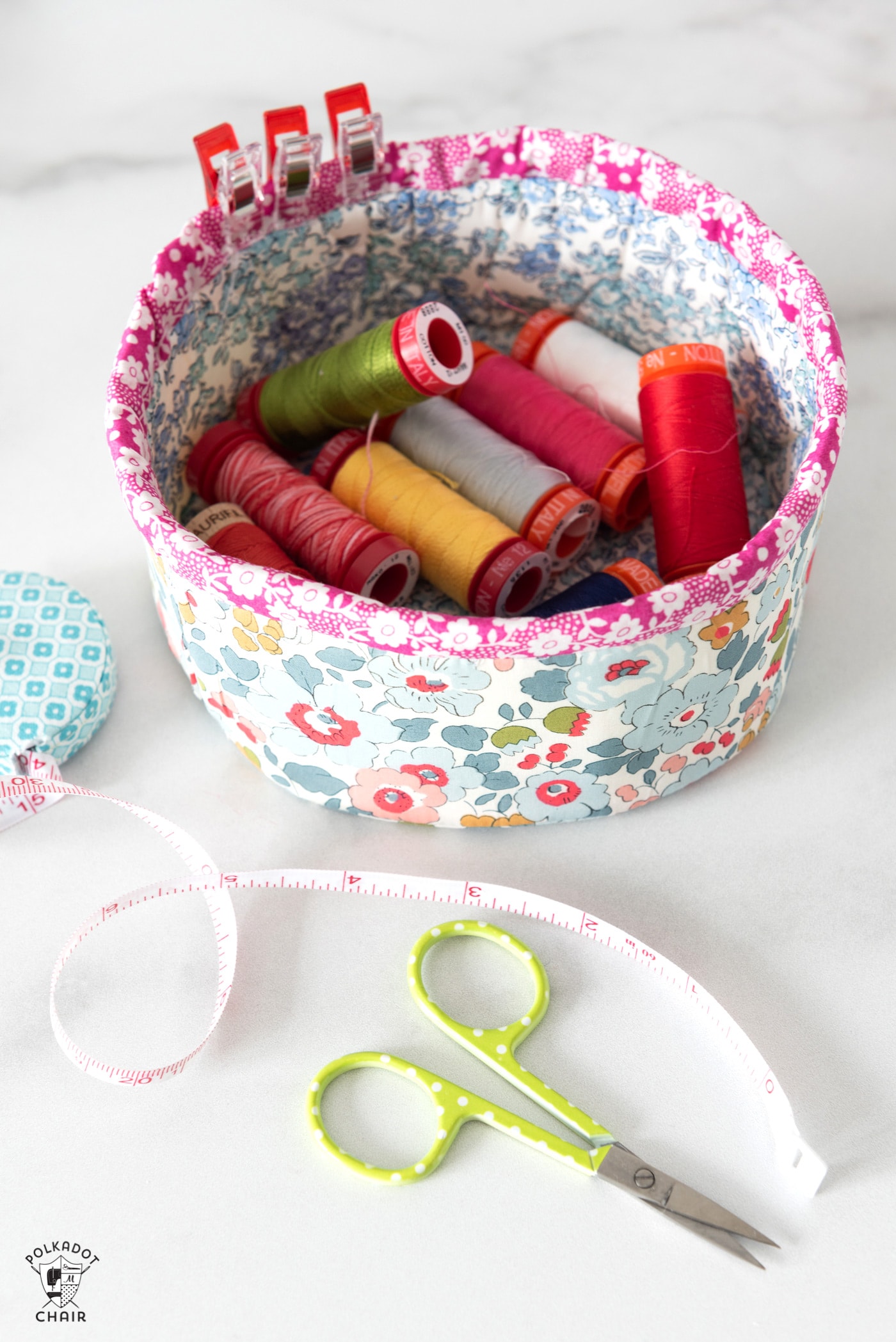 round fabric basket on marble table with sewing supplies