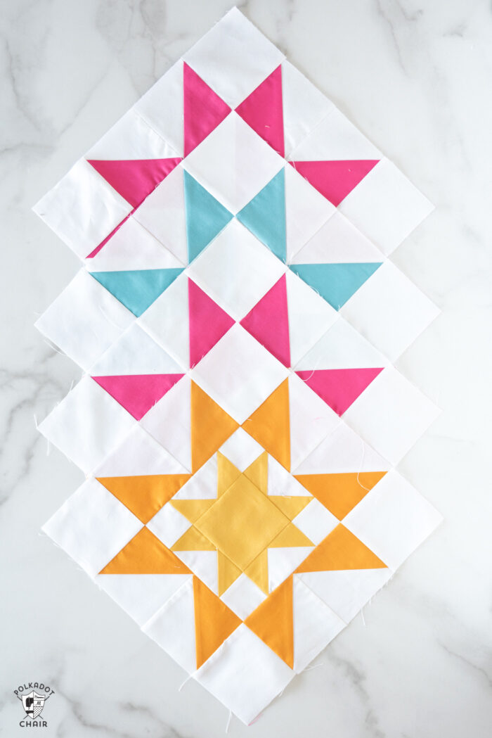 sawtooth star quilt blocks in blues, pinks and yellows on white tabletop