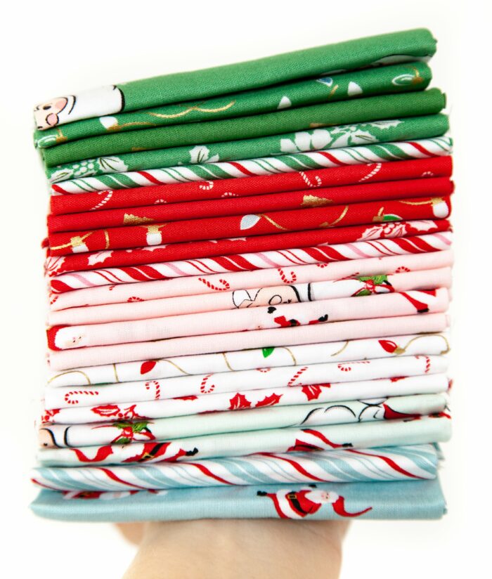 photo of a stack of folded santa claus lane fabric on white background