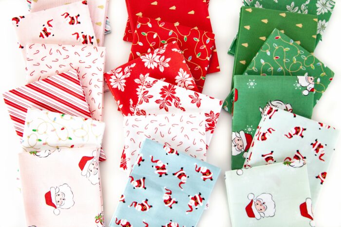 photo of a stack of folded santa claus lane fabric on white background