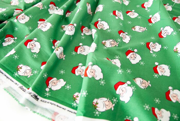 photo of a stack of folded santa claus lane fabric on white background