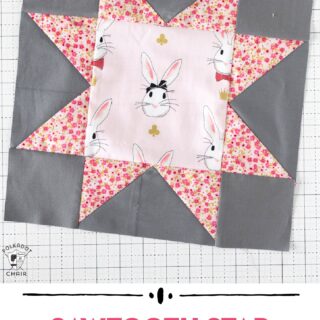 pink and gray sawtooth star quilt block on white cutting mat