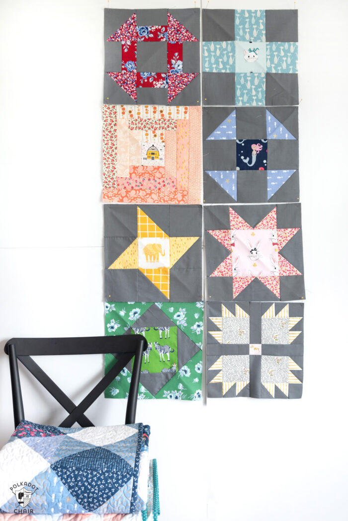 quilt blocks in various colors pinned to white wall