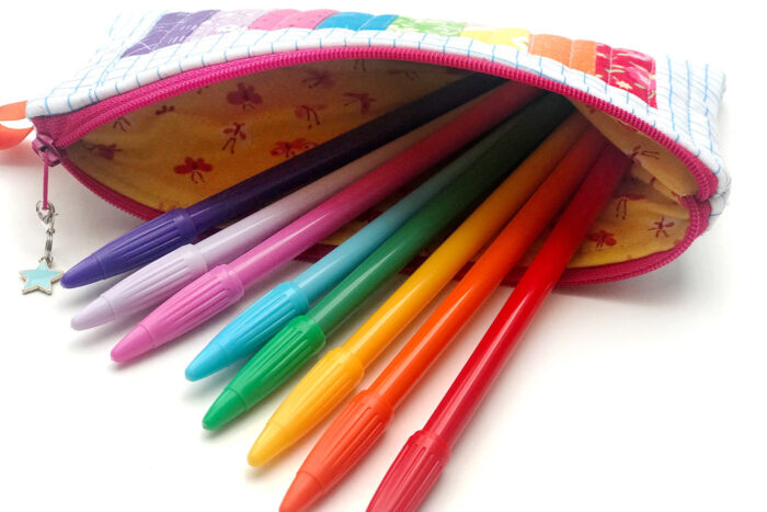 rainbow pencil pouch on white table with spools of thread and fabric