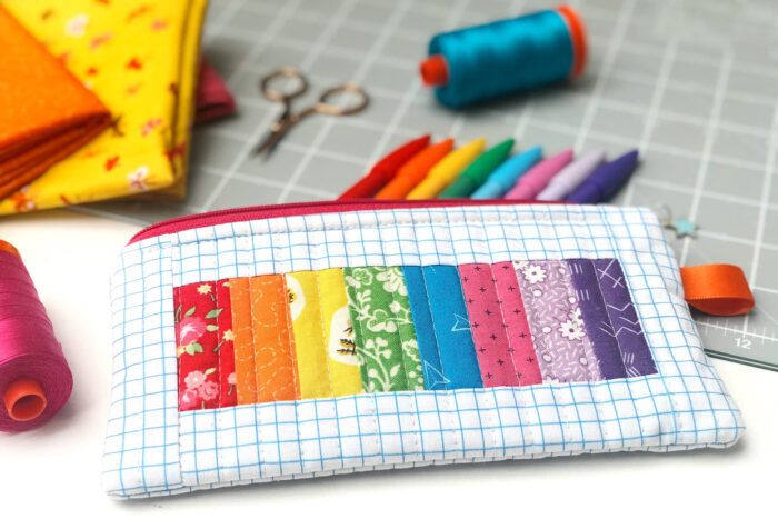 rainbow pencil pouch on white table with spools of thread and fabric