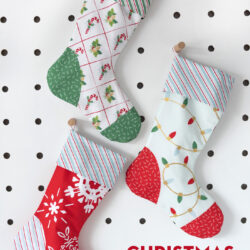 Red, blue and aqua christmas stockings on white peg board