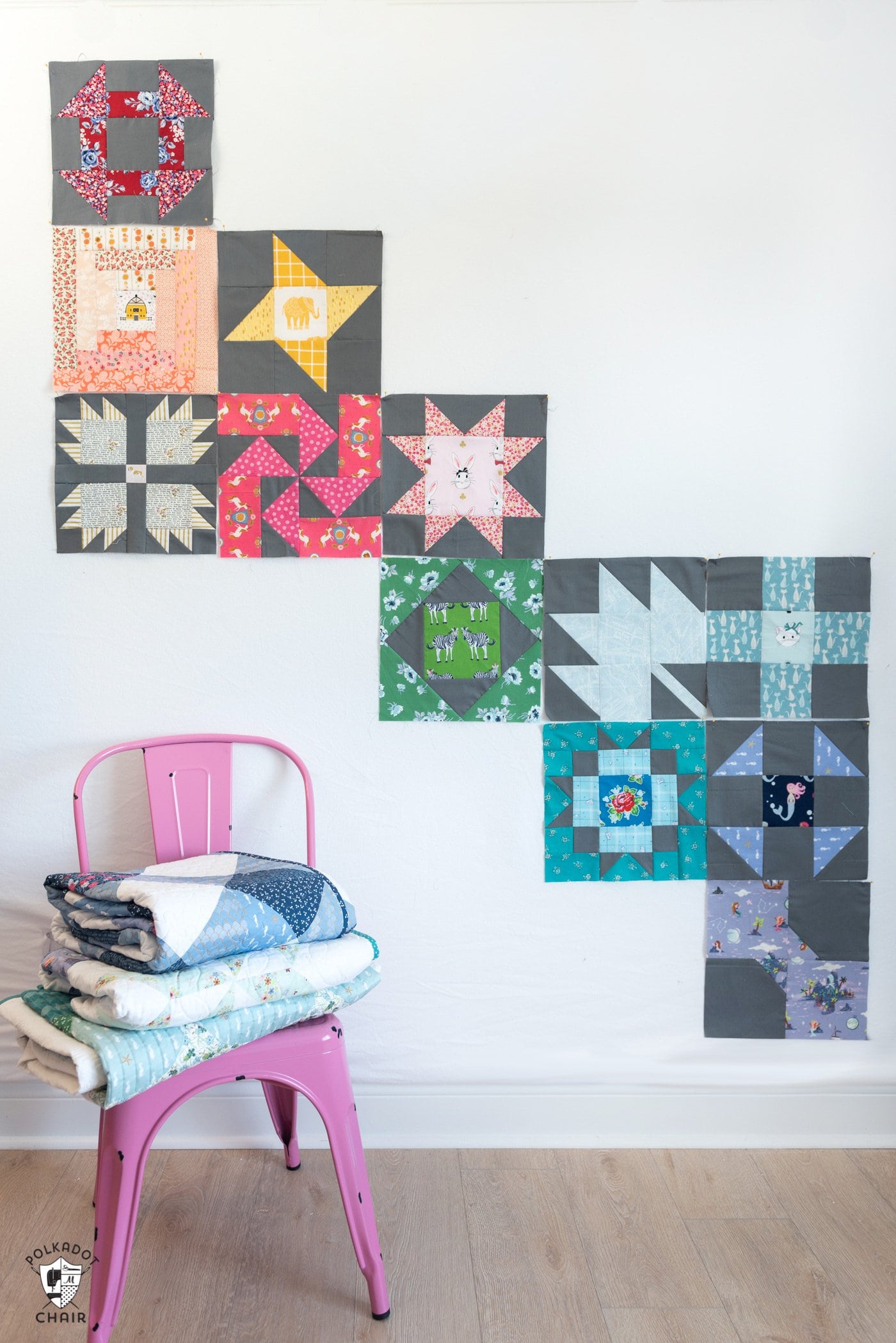 various quilt blocks pinned on white wall