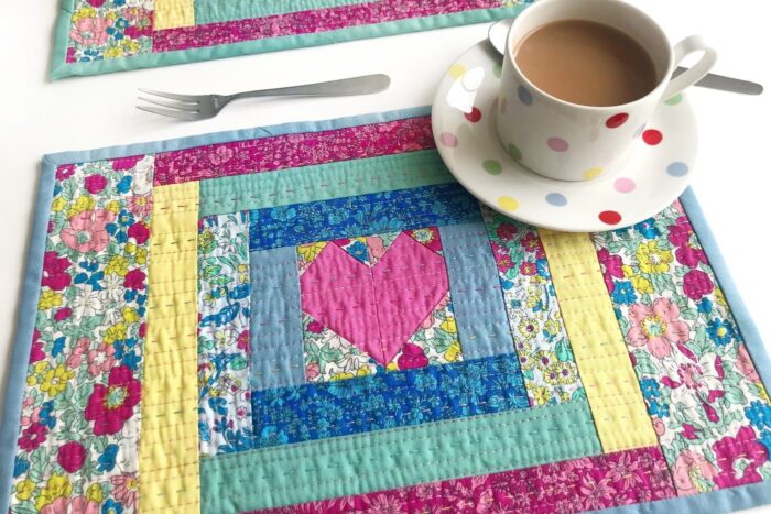 quilted placemat made from liberty fabrics on white table with polka dot tea cup