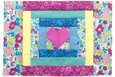 completed heart quilt block on white table