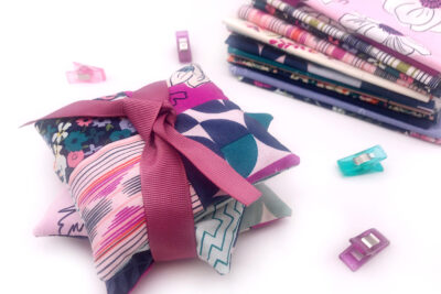 stack of lavender sachets tied up with ribbon on white table