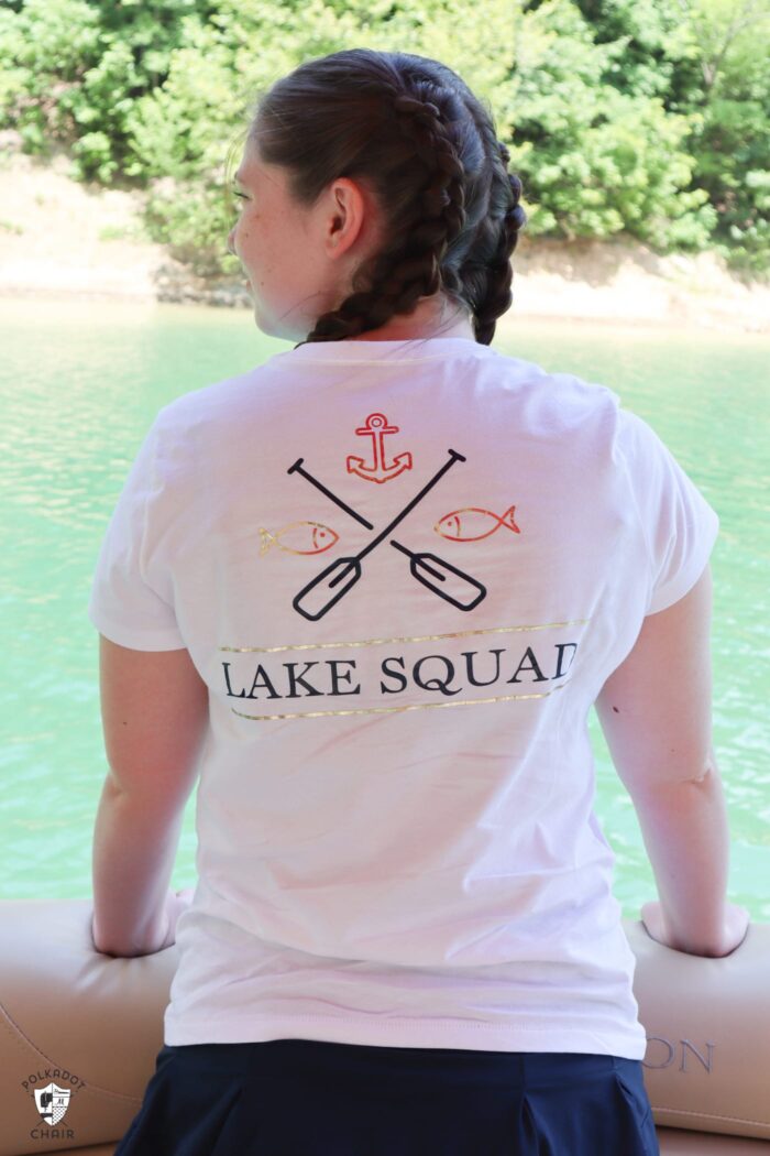 girl on boat looking out to lake wearing white t-shirt