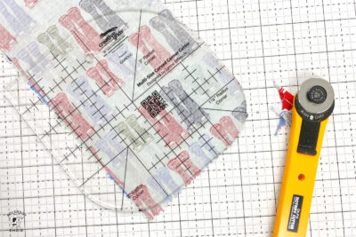 fabric being rounded at corners with ruler on white cutting mat