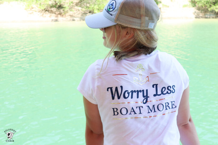 girl on boat looking out to lake wearing white t-shirt