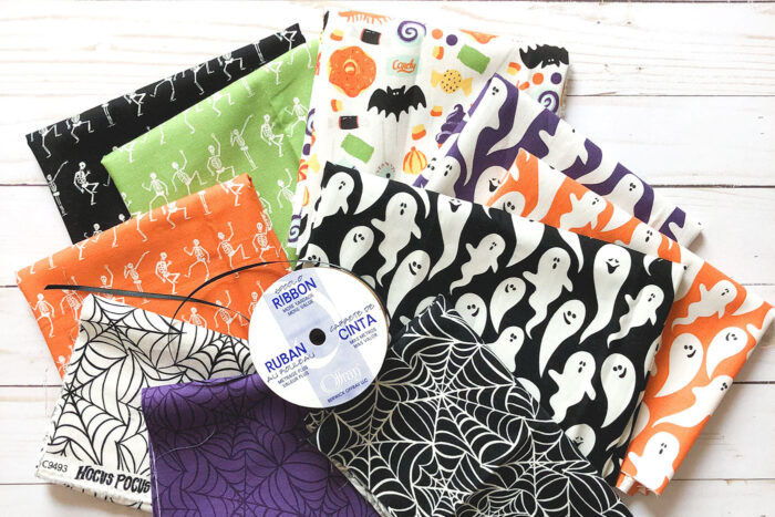 various multi colored halloween fabrics on white table