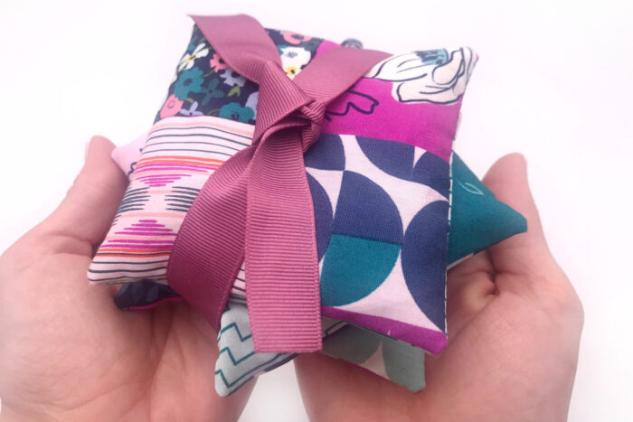 stack of lavender sachets tied up with ribbon on white table