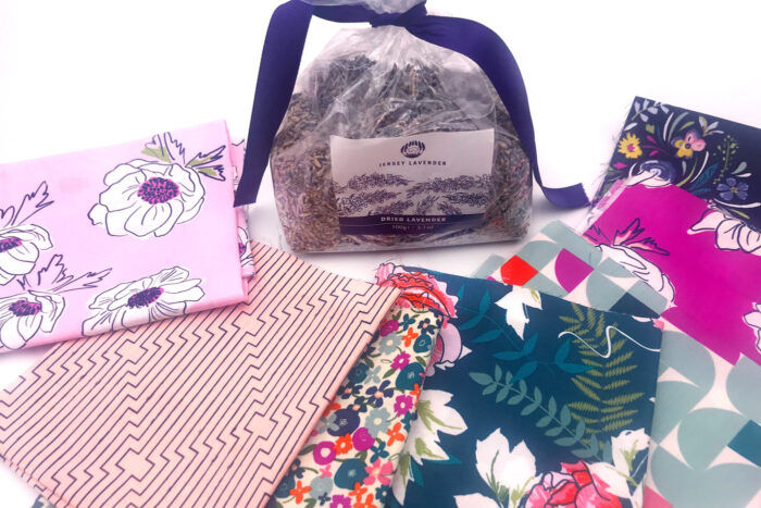 stacks of fabric and bag of lavender on white table