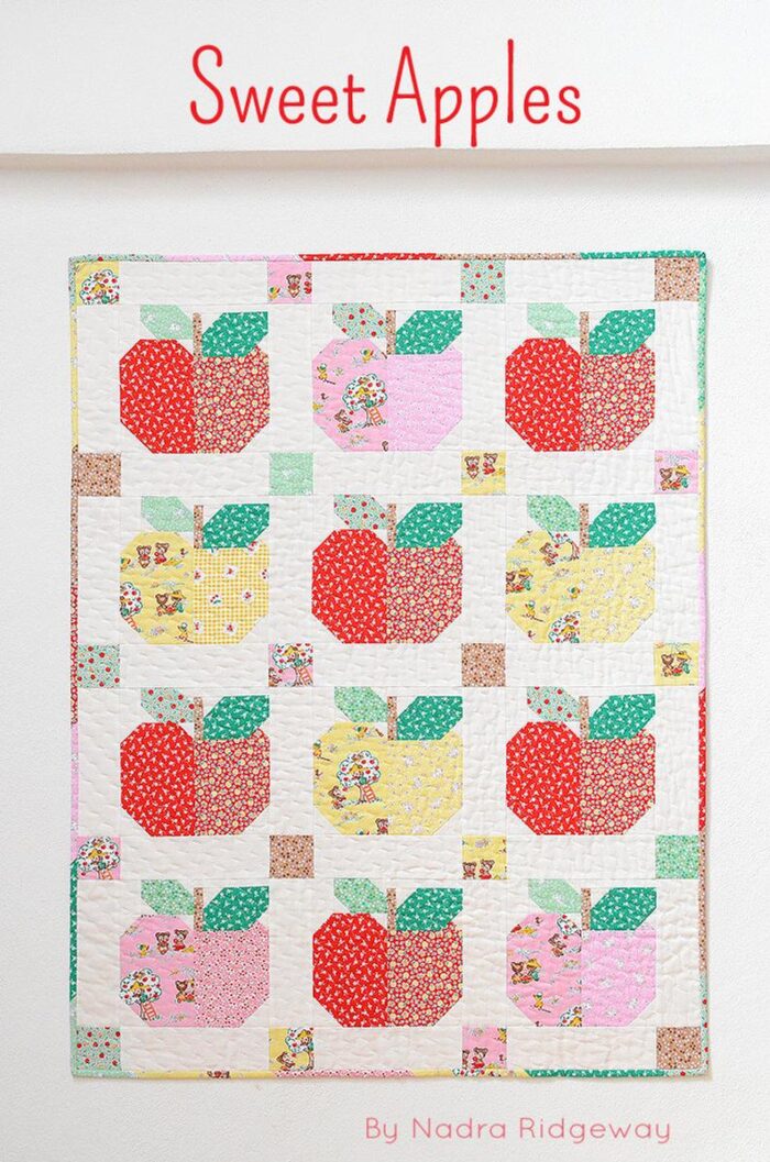 Apple quilt pattern in reds and yellows on white wall