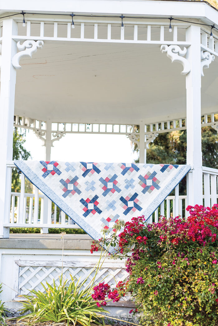 red white and blue quilt in white gazebo