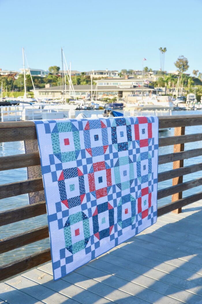 red white and blue quilt on fence at waterfront