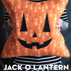 woman holding orange pumpkin pillow