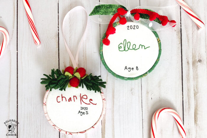 hand embroidered christmas ornaments with childrens names on white wood table