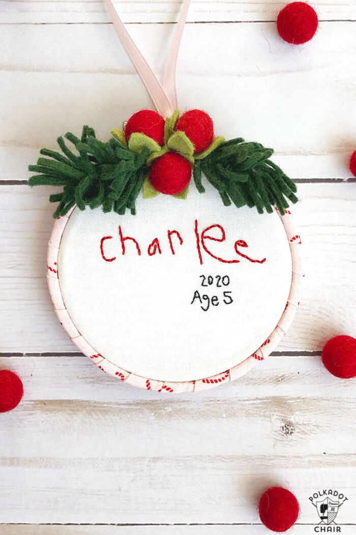 hand embroidered christmas ornaments with childrens names on white wood table