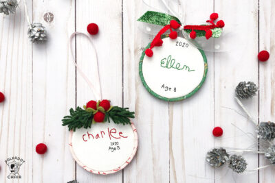 hand embroidered christmas ornaments with childrens names on white wood table