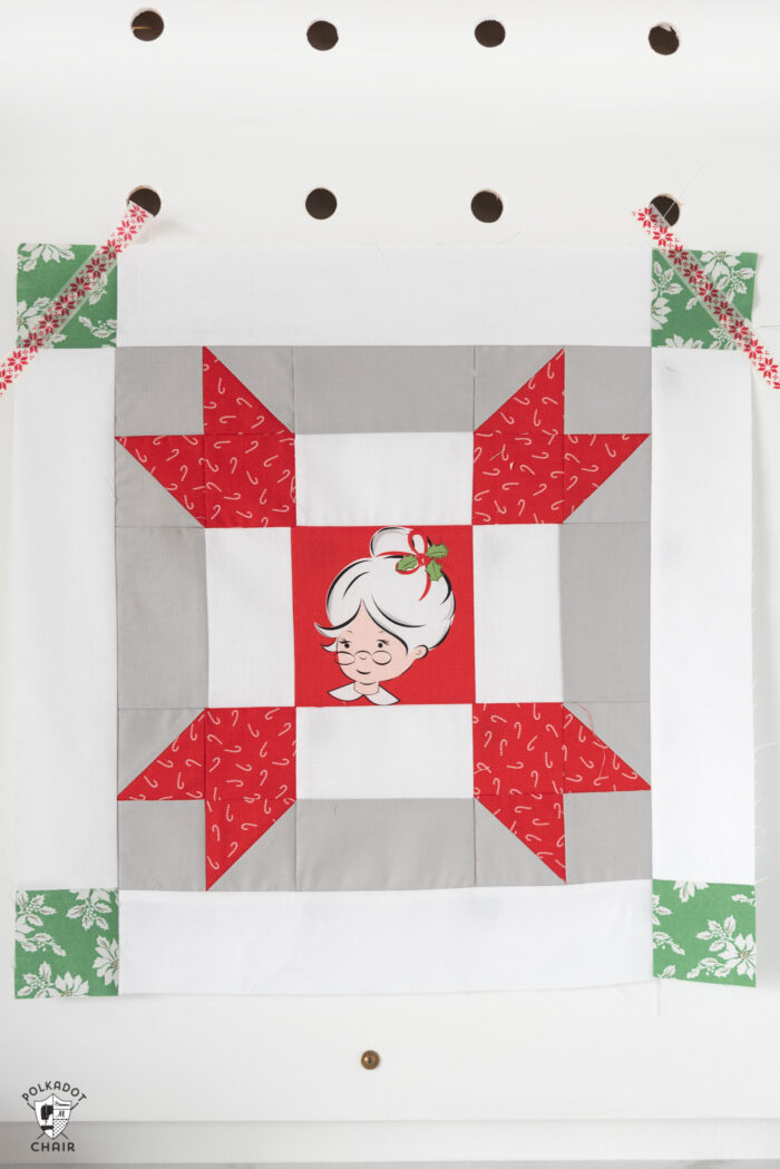 red and green christmas quilt blocks on peg board