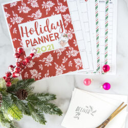 printed pages from christmas planner on white table with pens & scissors