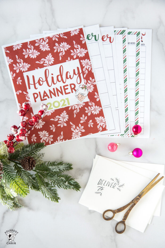 printed pages from christmas planner on white table with pens & scissors