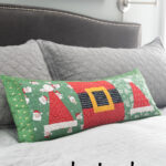 quilted christmas pillow on gray bed