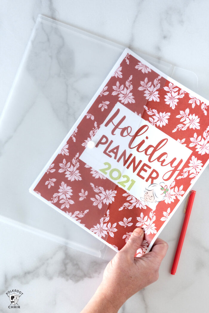 hand holding christmas planner in clear envelope