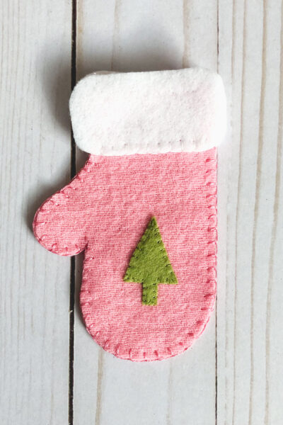 pieces of felt mitten cut out on white wood table