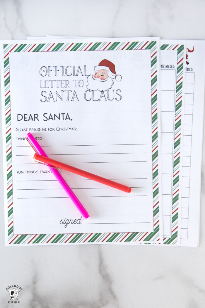 printed pages of Christmas planner on white table with pens