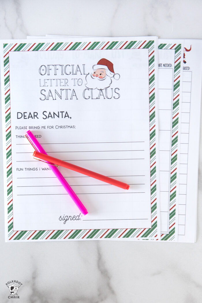 printed pages from christmas planner on white table with pens
