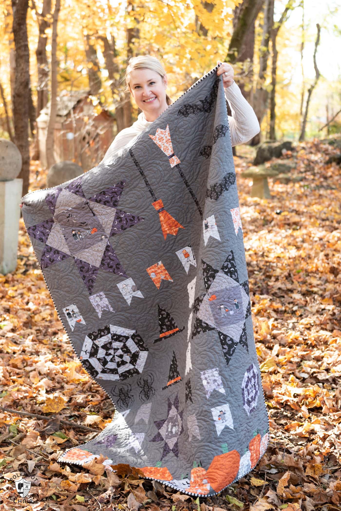 woman holding Halloween quilt outdoors