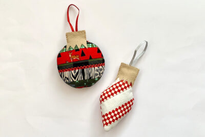 Finished scrappy Christmas ornament in red and green on white table