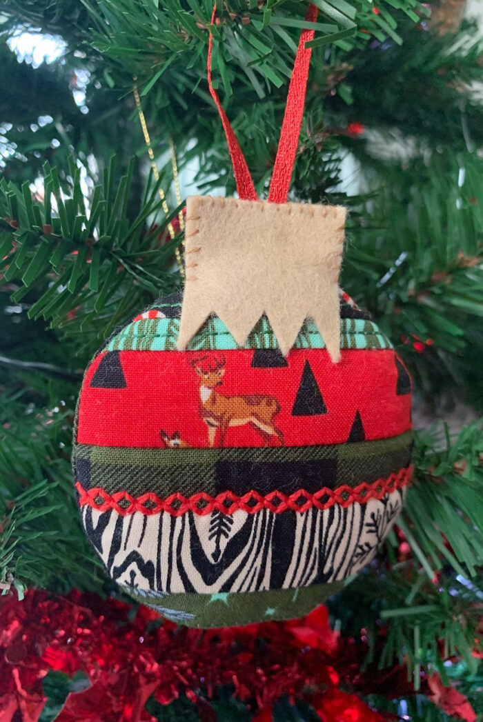 Finished scrappy Christmas ornament in red and green on Christmas Tree