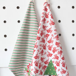 Two holiday tea towels on white table