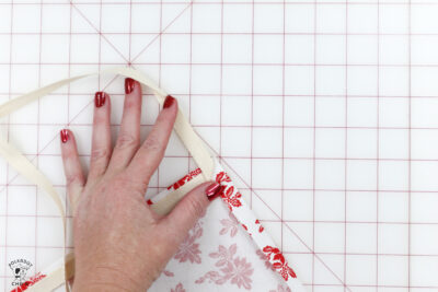 hand folding fabric on white cutting mat