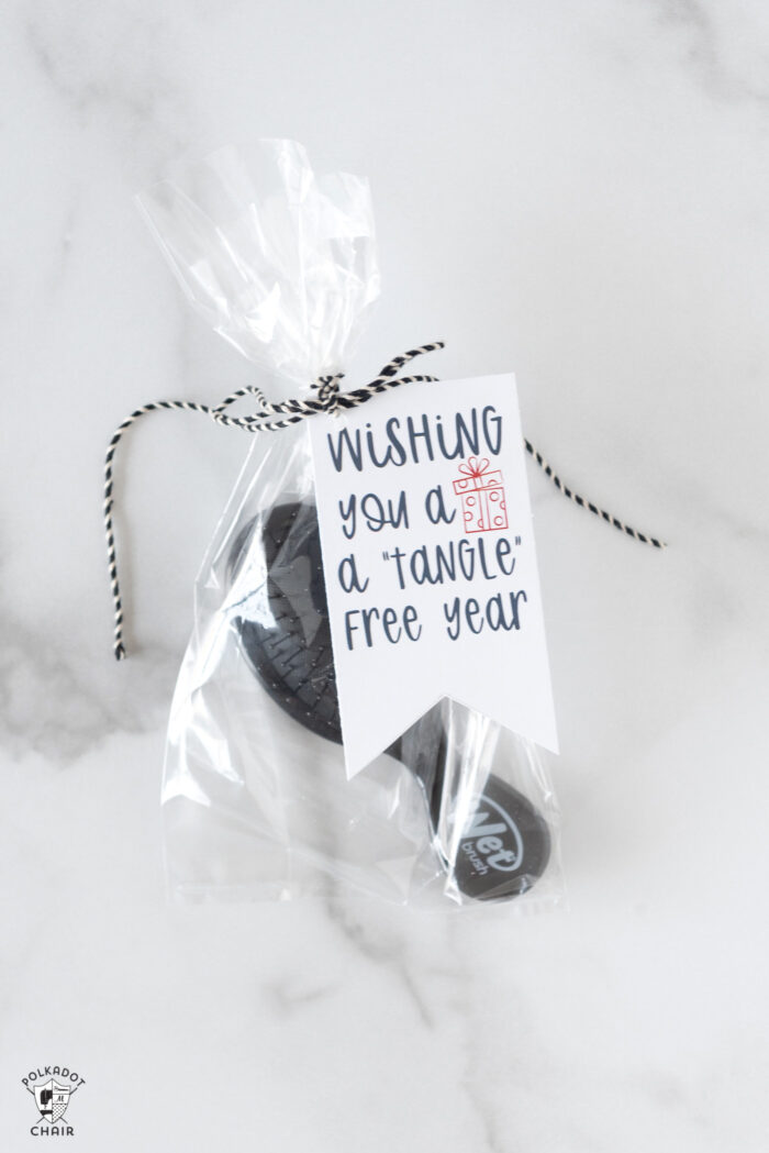 gift bags with a brush and tags on white marble table