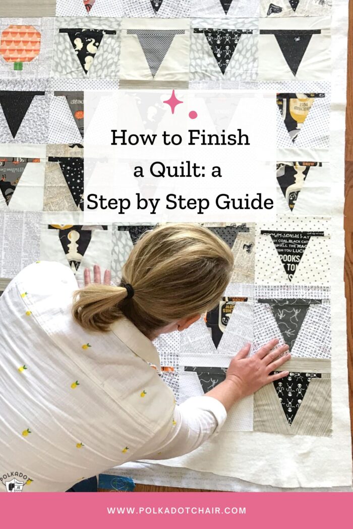 woman smoothing out black and white quilt on floor