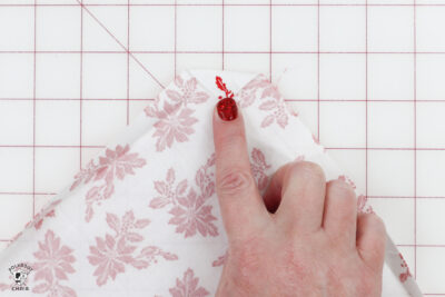 hand folding fabric on white cutting mat