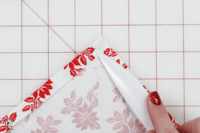 hand folding fabric on white cutting mat