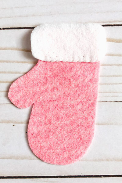 pieces of felt mitten cut out on white wood table