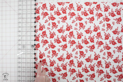 hand folding fabric on white cutting mat