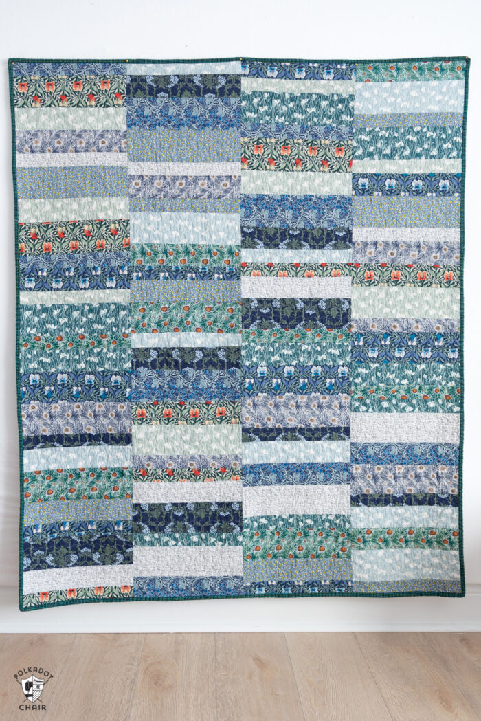 photo of a blue, green quilt on white wall